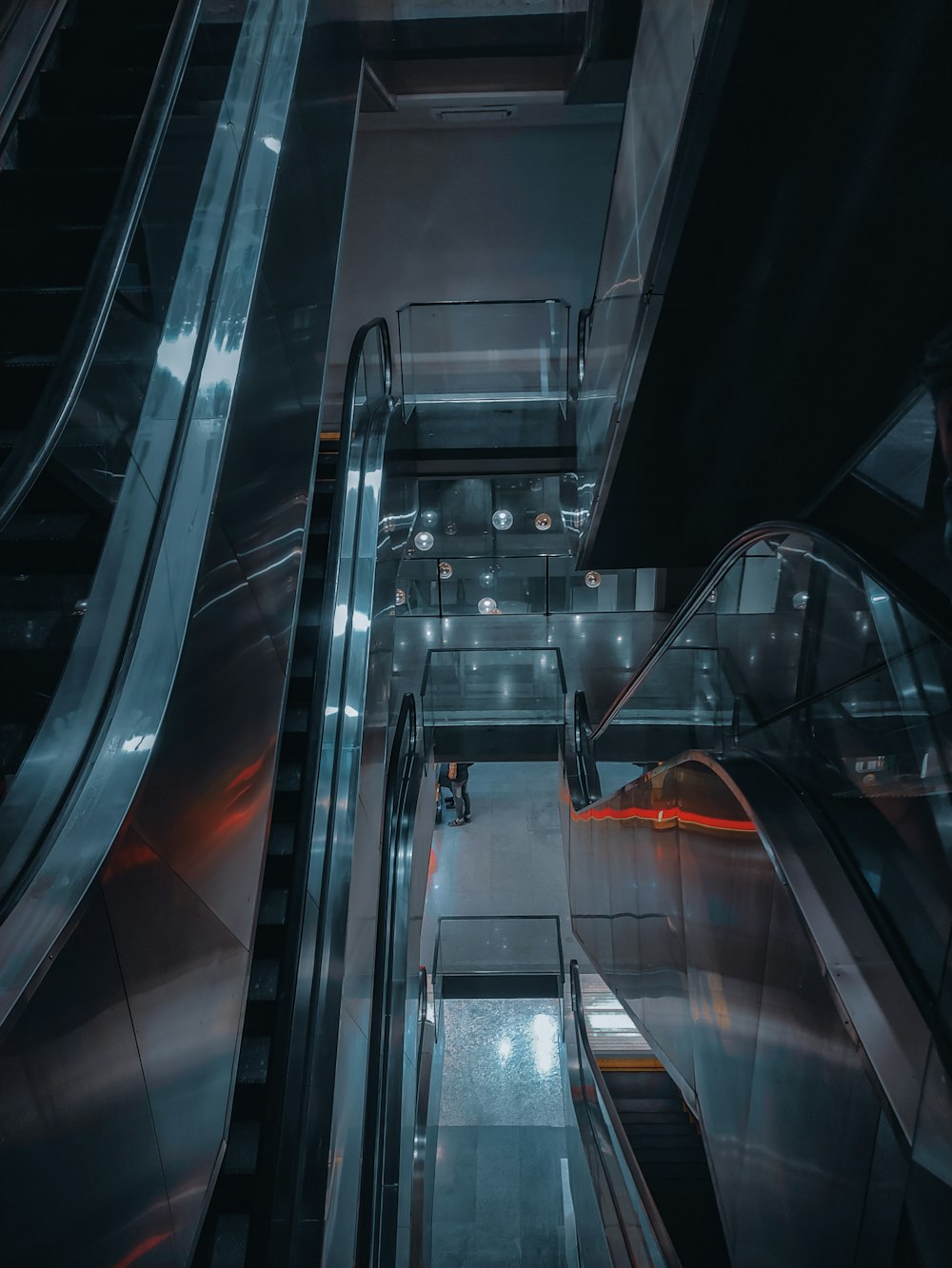 an escalator in a subway station with a person riding an escalator