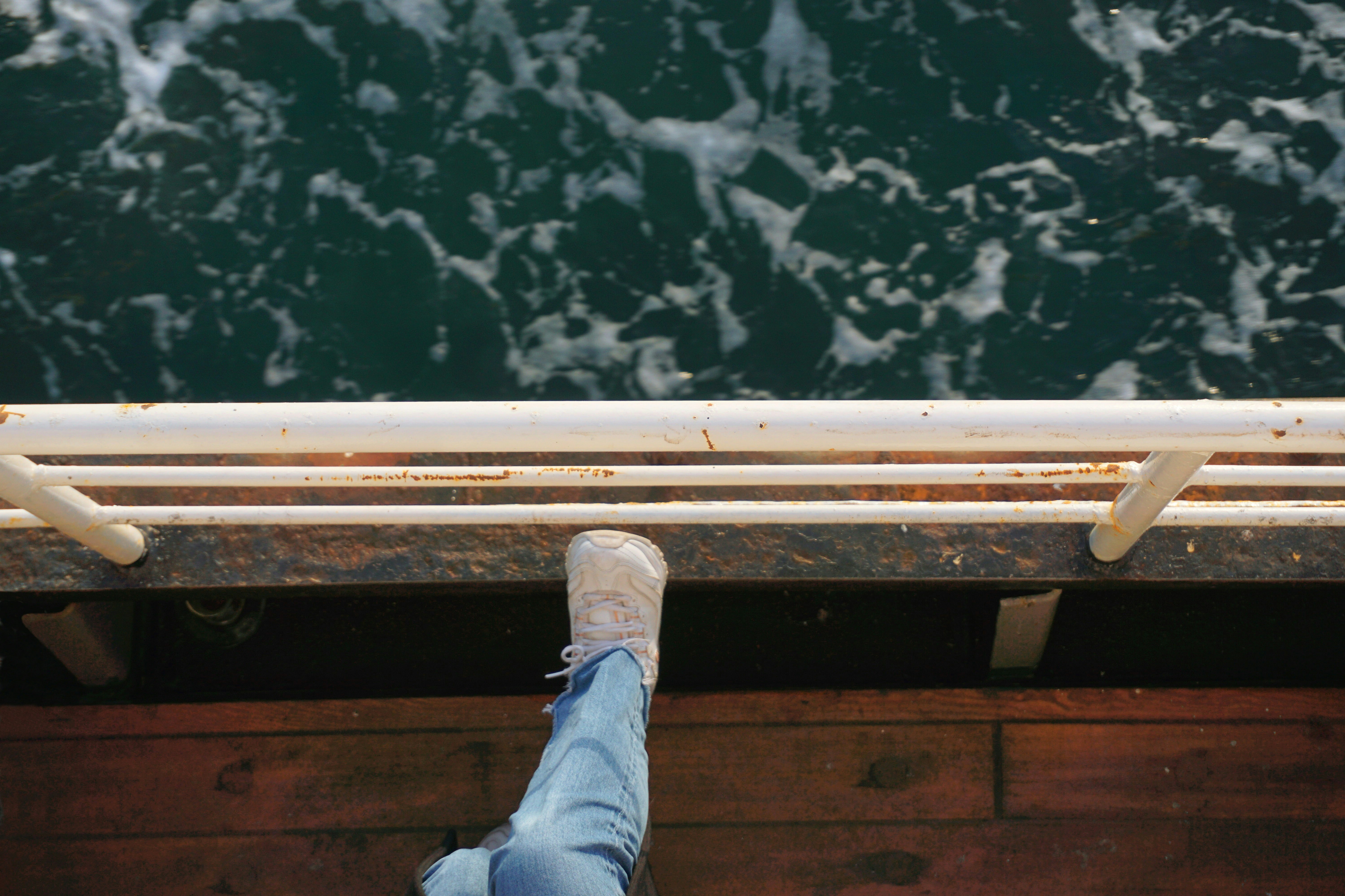 a person standing on a dock with their feet up