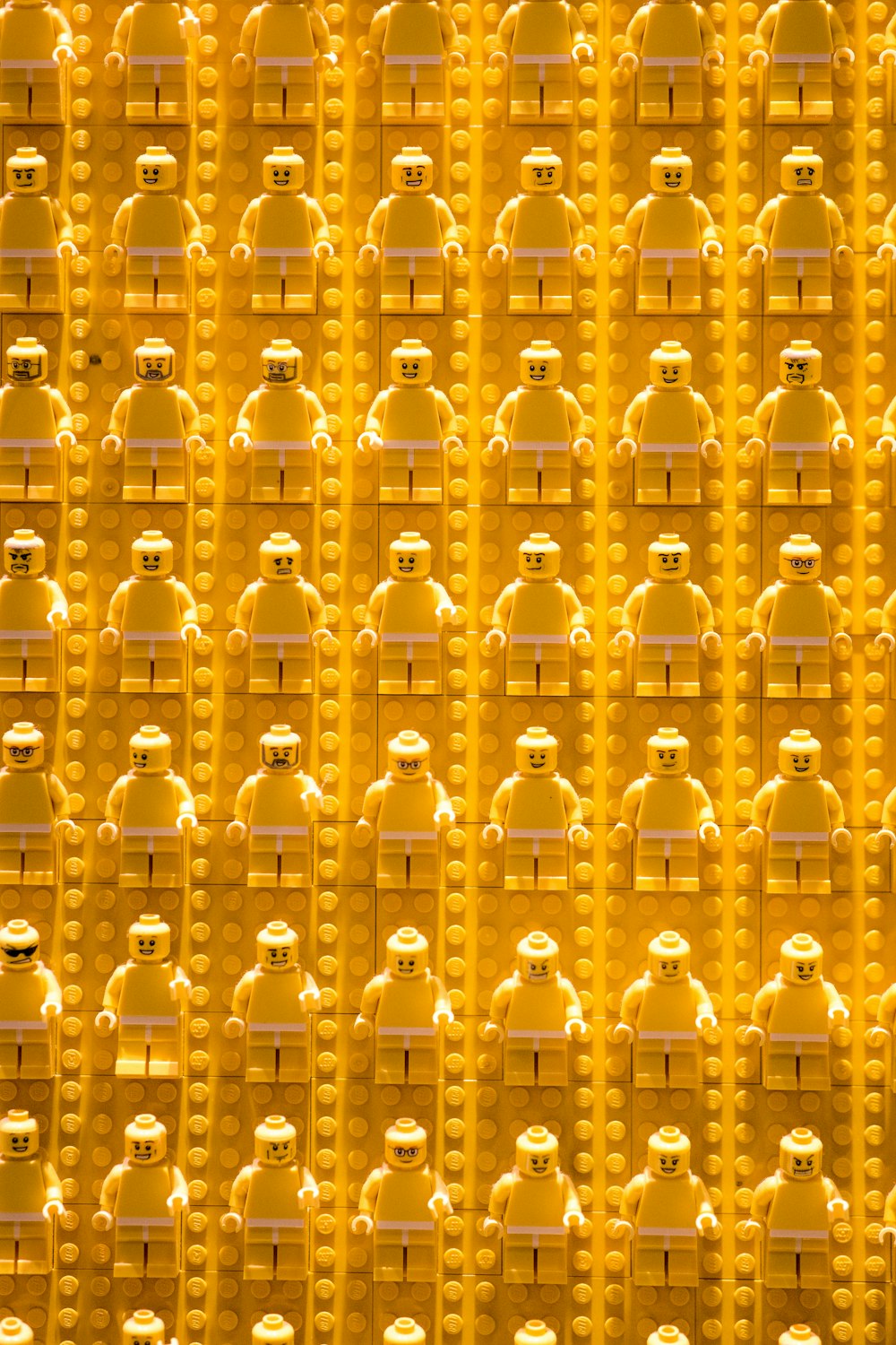 a large group of yellow legos with faces on them