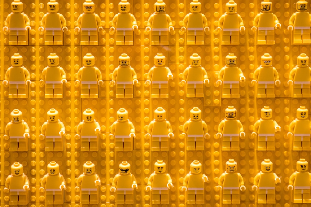 a group of yellow legos with faces on them