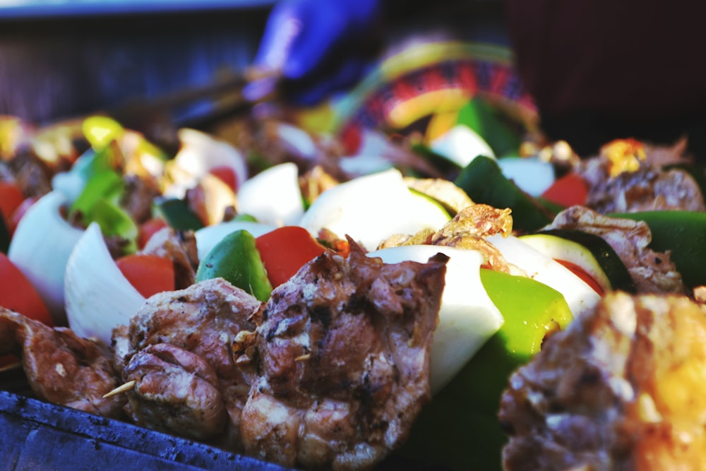 a close up of a tray of food with meat and veggies