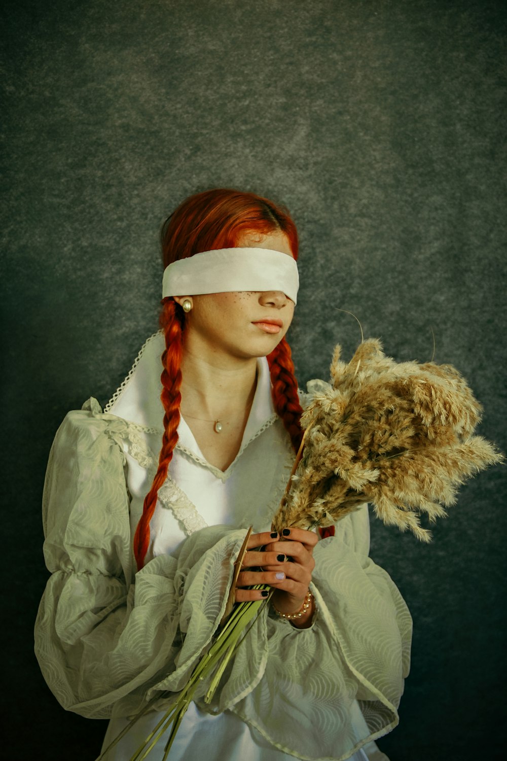 a woman with a blindfold holding a flower
