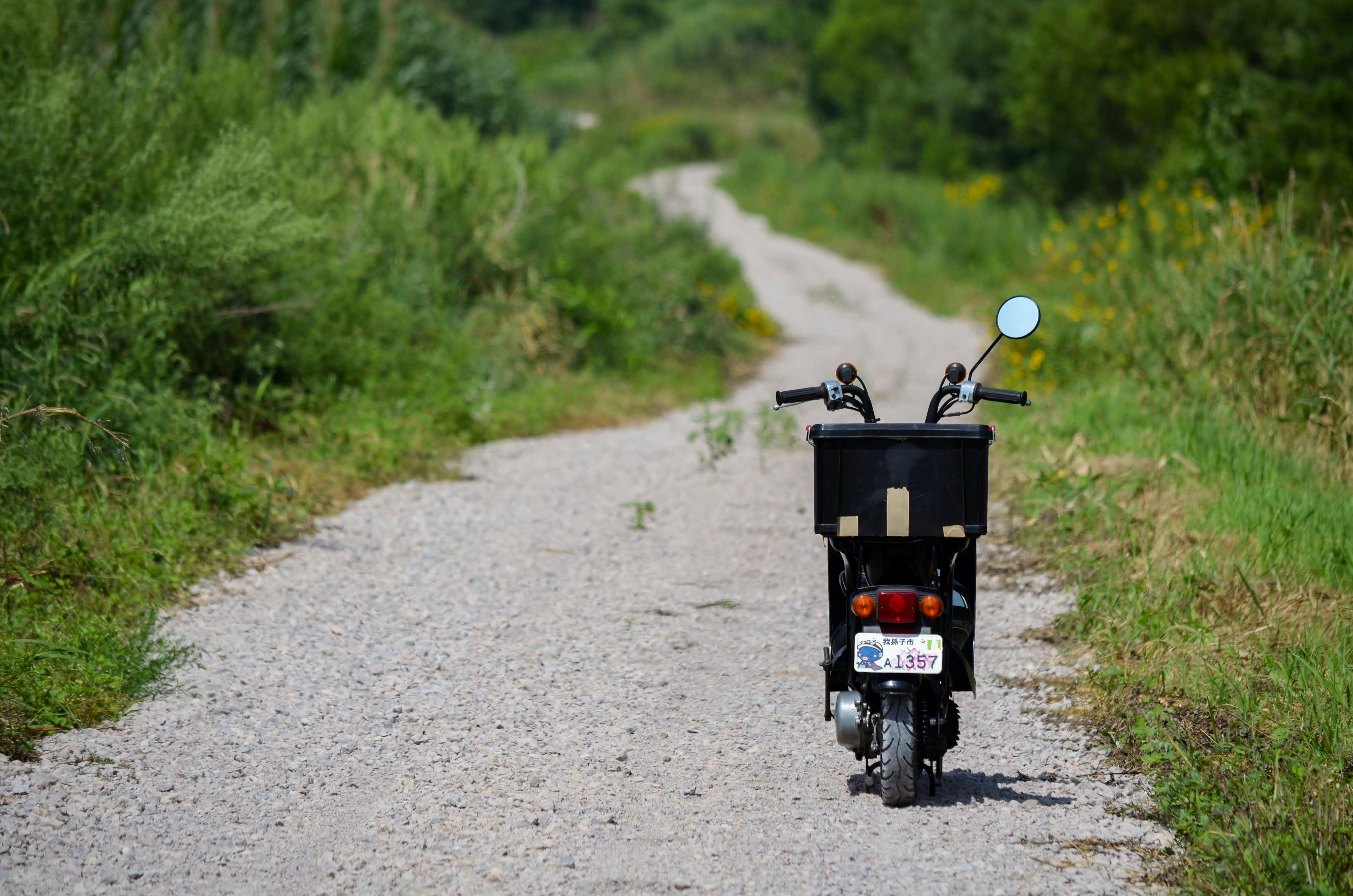 a motorcycle parked on the side of a dirt road