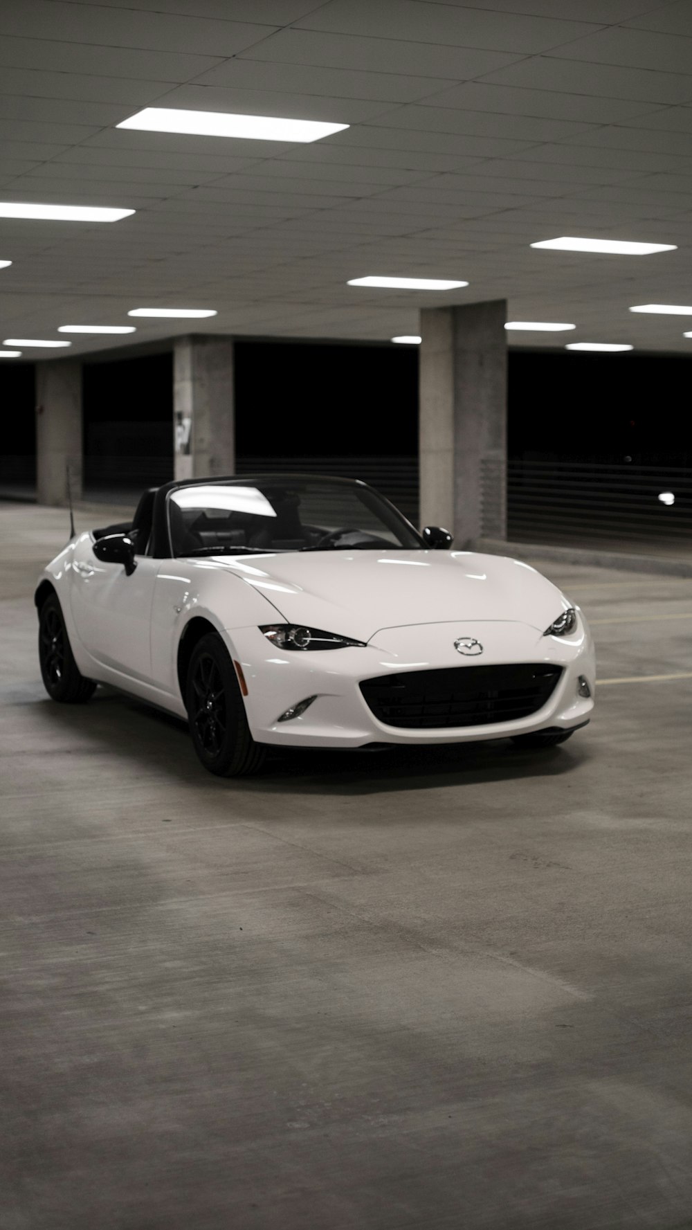 a white sports car parked in a parking garage