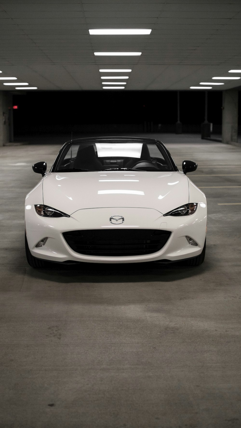 a white sports car parked in a parking garage