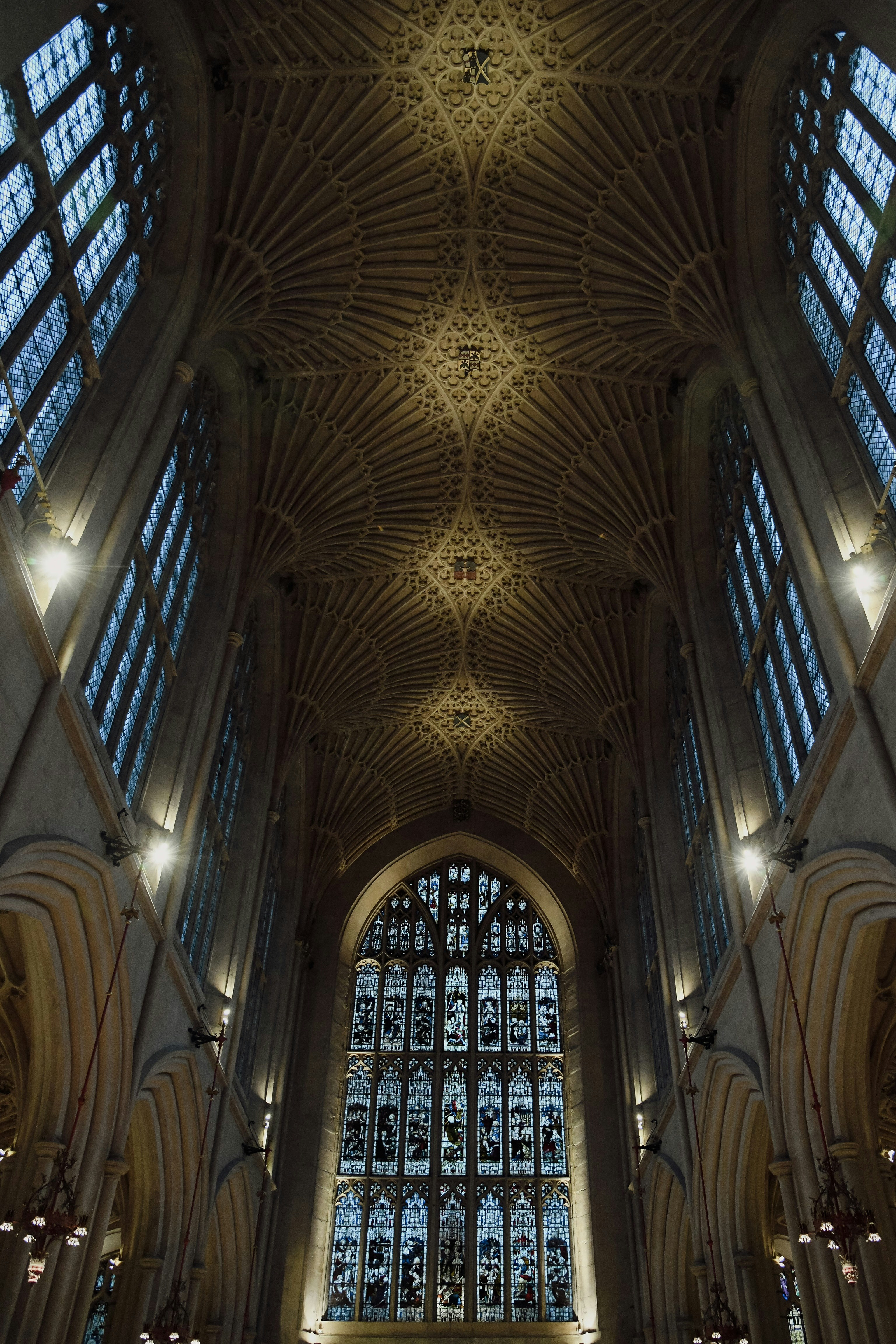 the ceiling of a large cathedral with a massive stained glass window