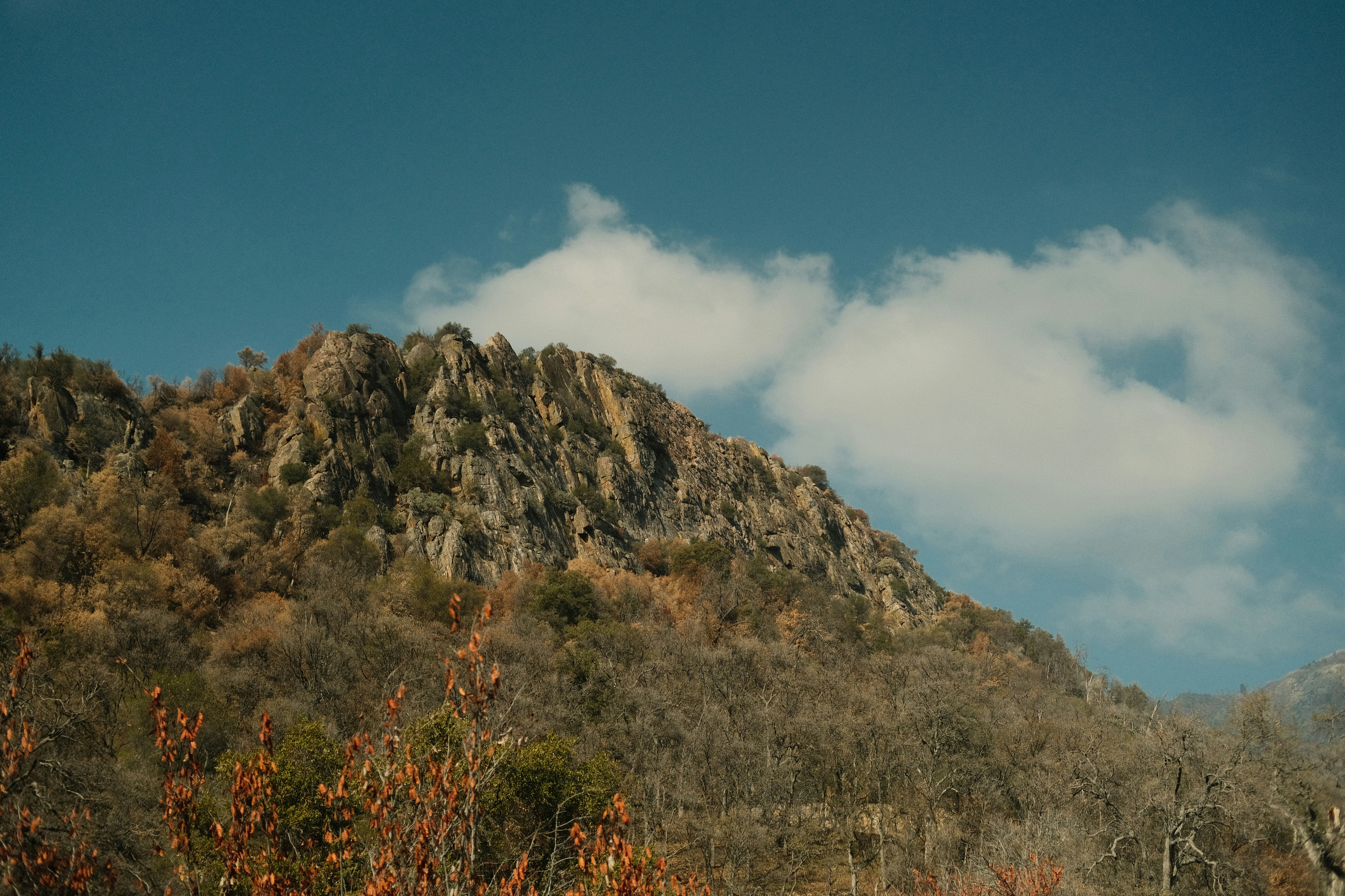 a very tall mountain with a few clouds in the sky
