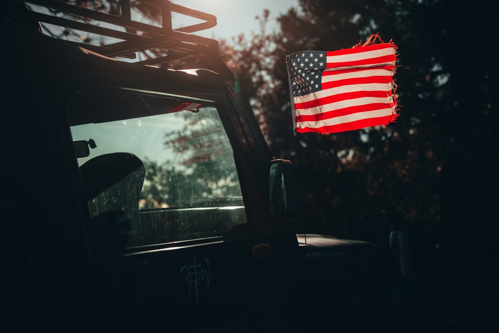 an american flag hanging from the back of a truck