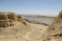a group of people standing on top of a sandy hill
