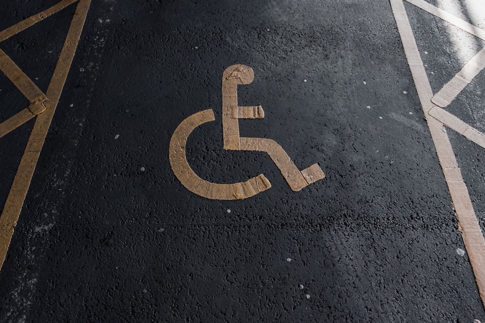 Un letrero para discapacitados en el suelo en un estacionamiento