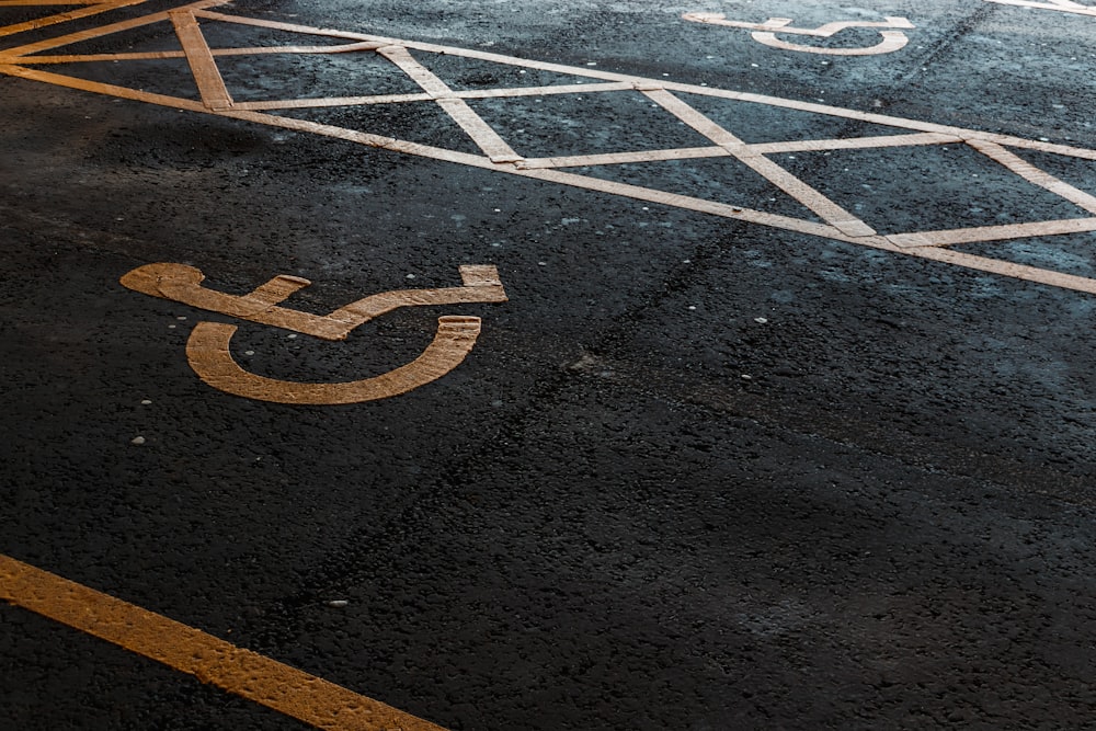 une place de parking avec un panneau pour handicapés peint dessus