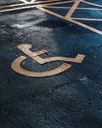 a handicapped sign on the ground in a parking lot