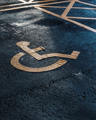 a handicapped sign on the ground in a parking lot