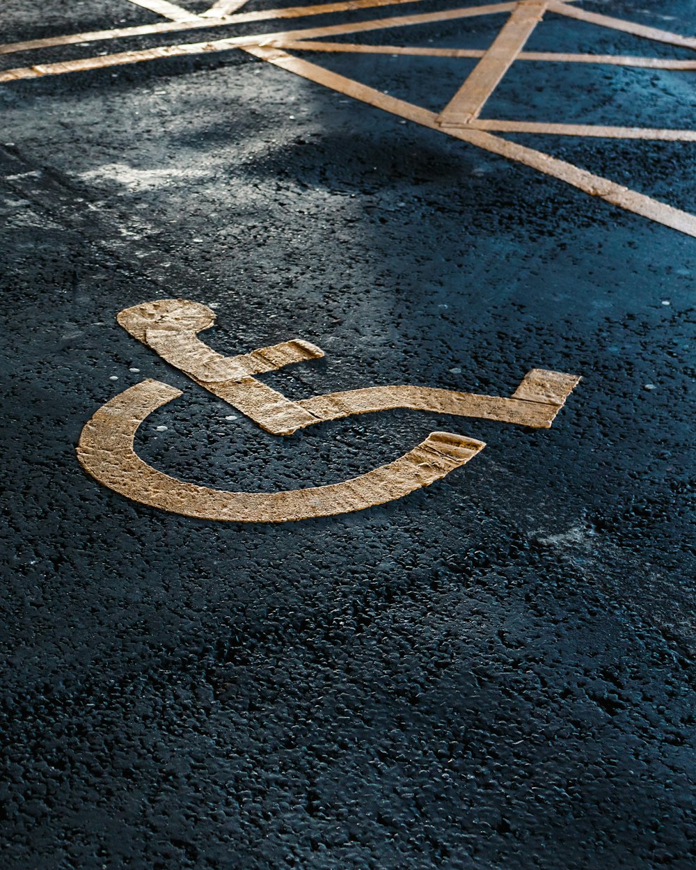 a handicapped sign on the ground in a parking lot