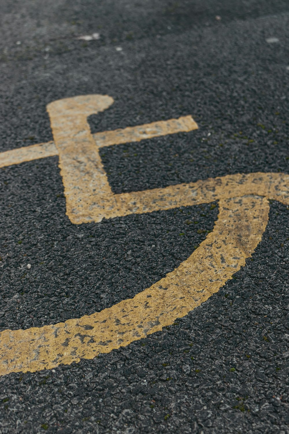ein Behindertenschild auf dem Asphalt einer Straße