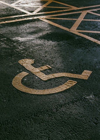 a handicapped sign painted on the pavement of a parking lot