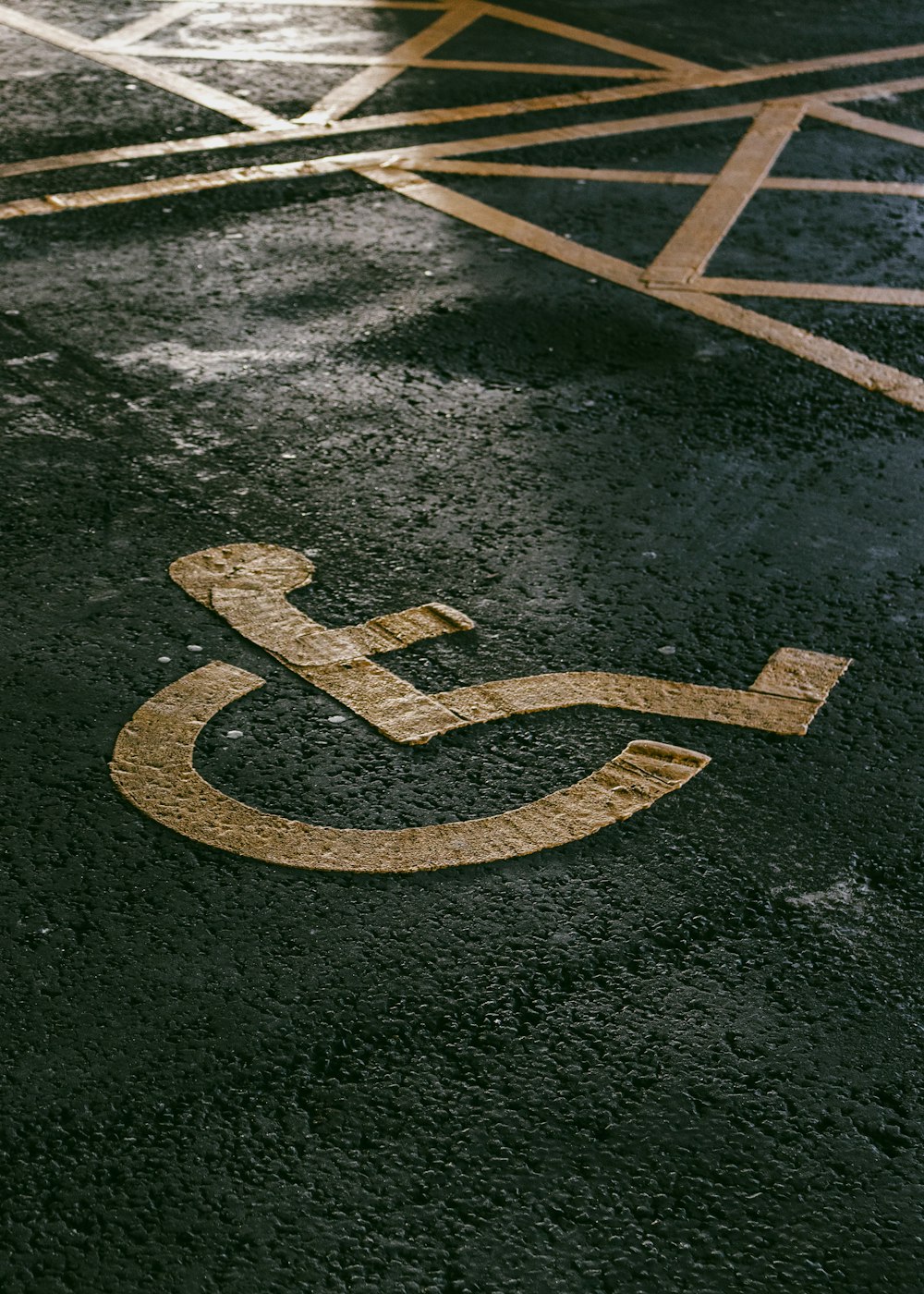 a handicapped sign painted on the pavement of a parking lot