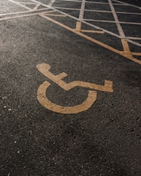 A parking lot featuring handicap symbols and directional arrows.