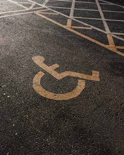 A parking lot featuring handicap symbols and directional arrows.