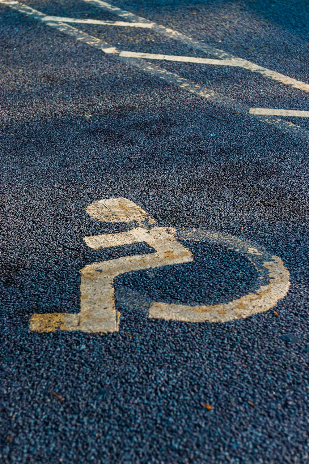 a handicapped sign painted on the asphalt of a street