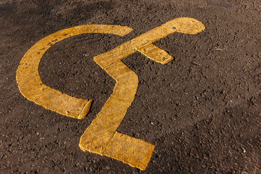 a yellow arrow painted on the ground in the middle of the road