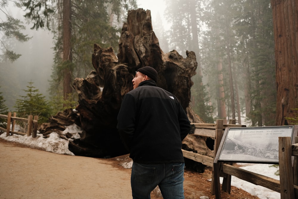 a man standing in front of a fallen tree