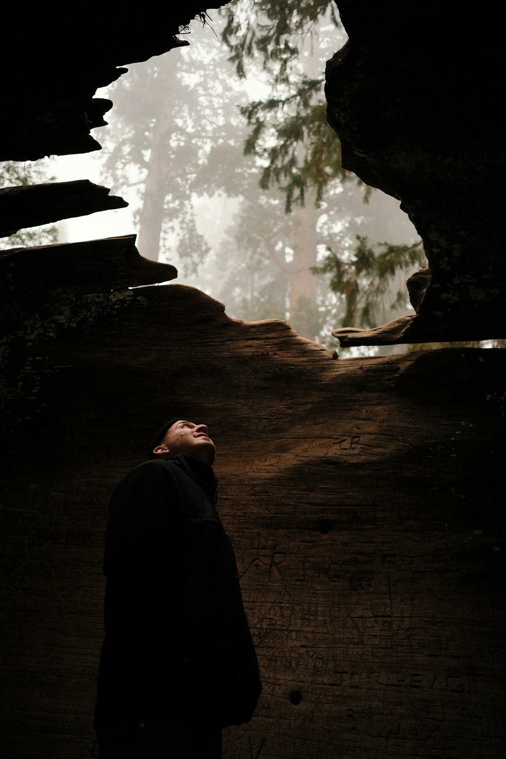 a man looking up into the sky in a cave