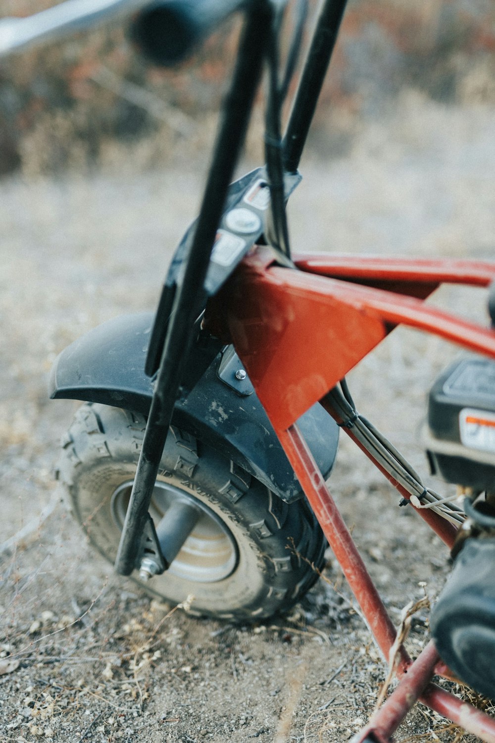 Un scooter rojo sentado encima de un campo de tierra