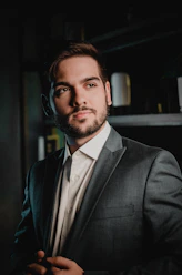 a man in a suit and tie standing in a dark room