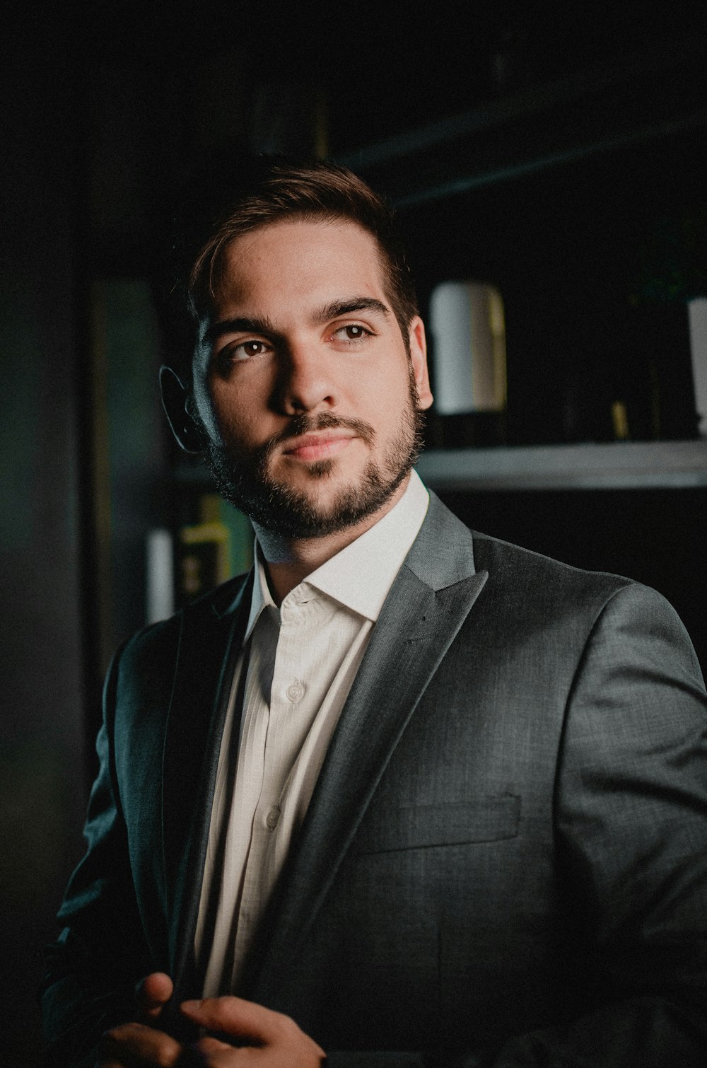 a man in a suit and tie standing in a dark room