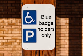 a blue and white sign that says blue badge holders only