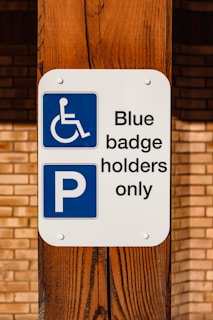 a blue and white sign that says blue badge holders only
