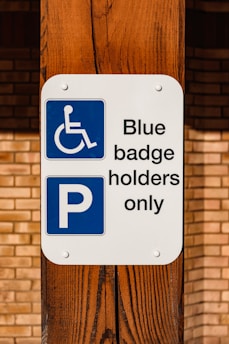 a blue and white sign that says blue badge holders only