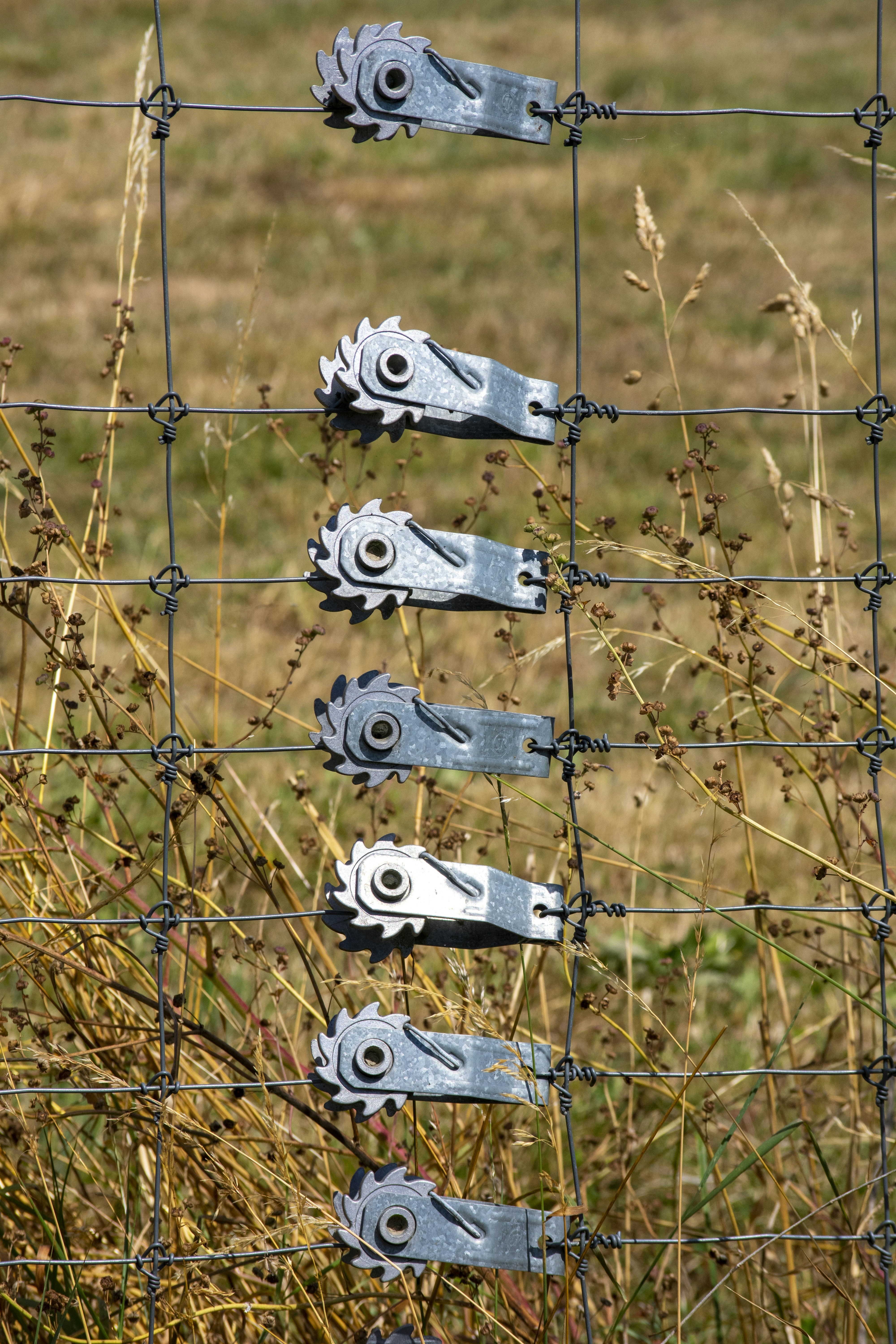 a wire fence with a bunch of tools attached to it