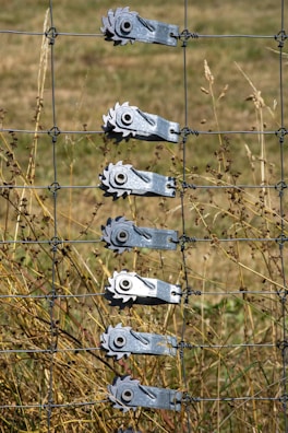 a wire fence with a bunch of tools attached to it