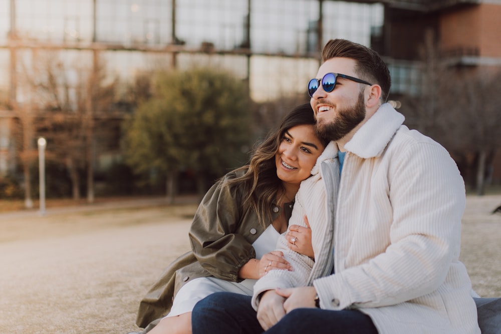 a man and a woman sitting on the ground