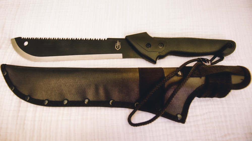 a knife and sheath laying on a bed