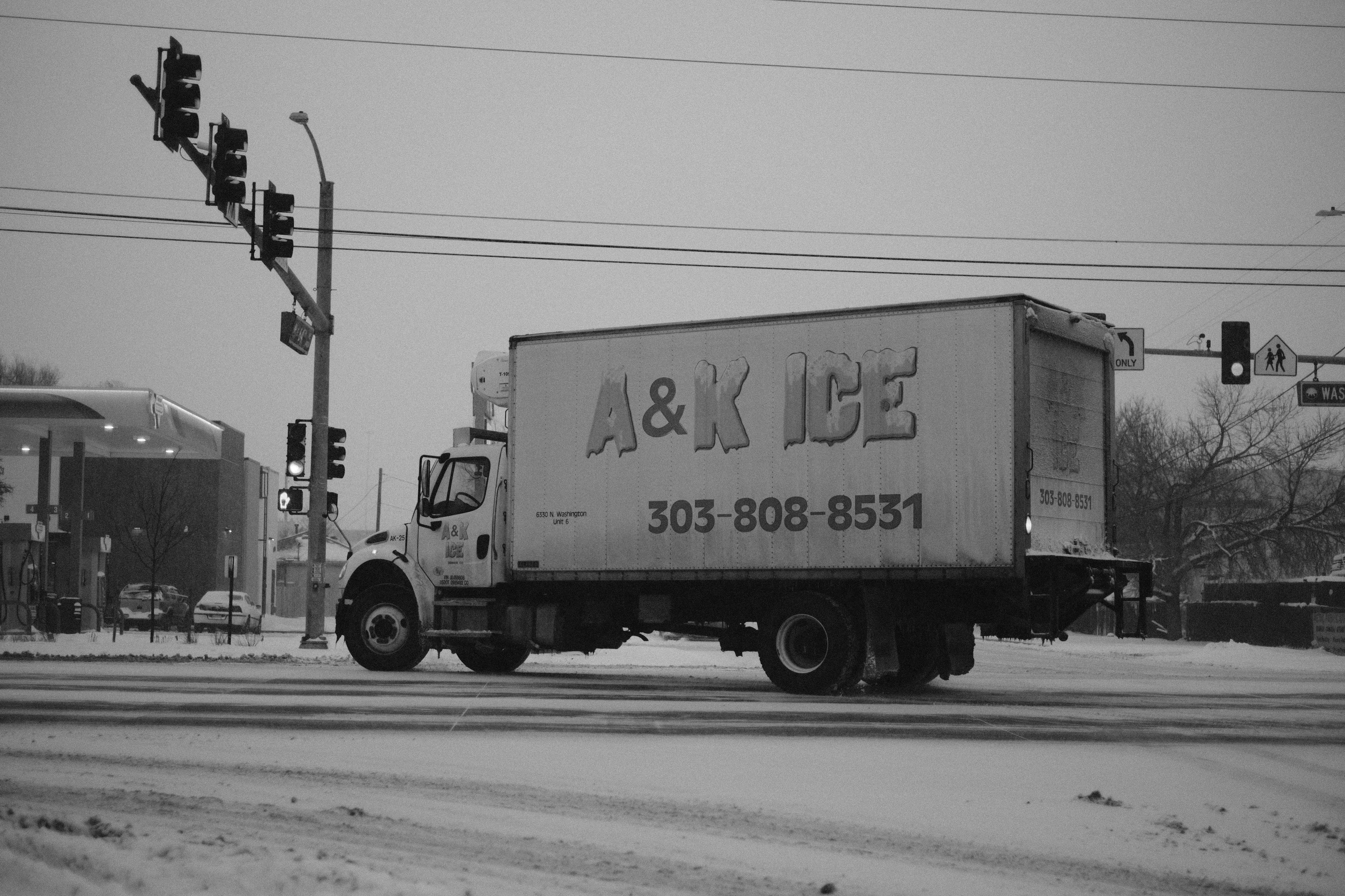 a truck driving down a street next to a traffic light