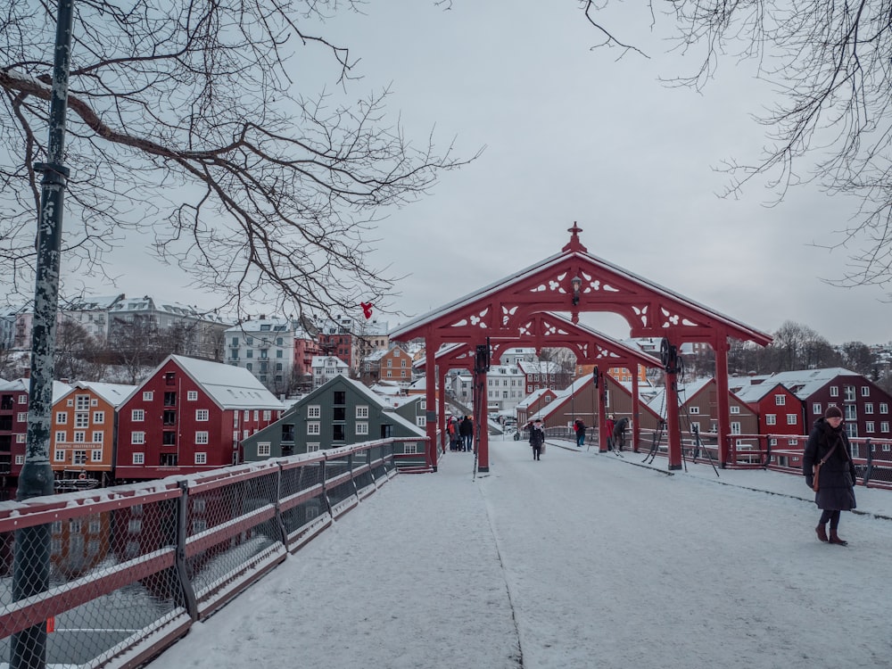 people walking across a bridge in the snow
