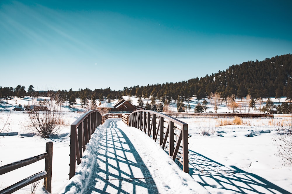eine Holzbrücke über ein schneebedecktes Feld