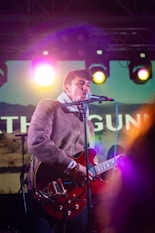 a man that is standing up with a guitar