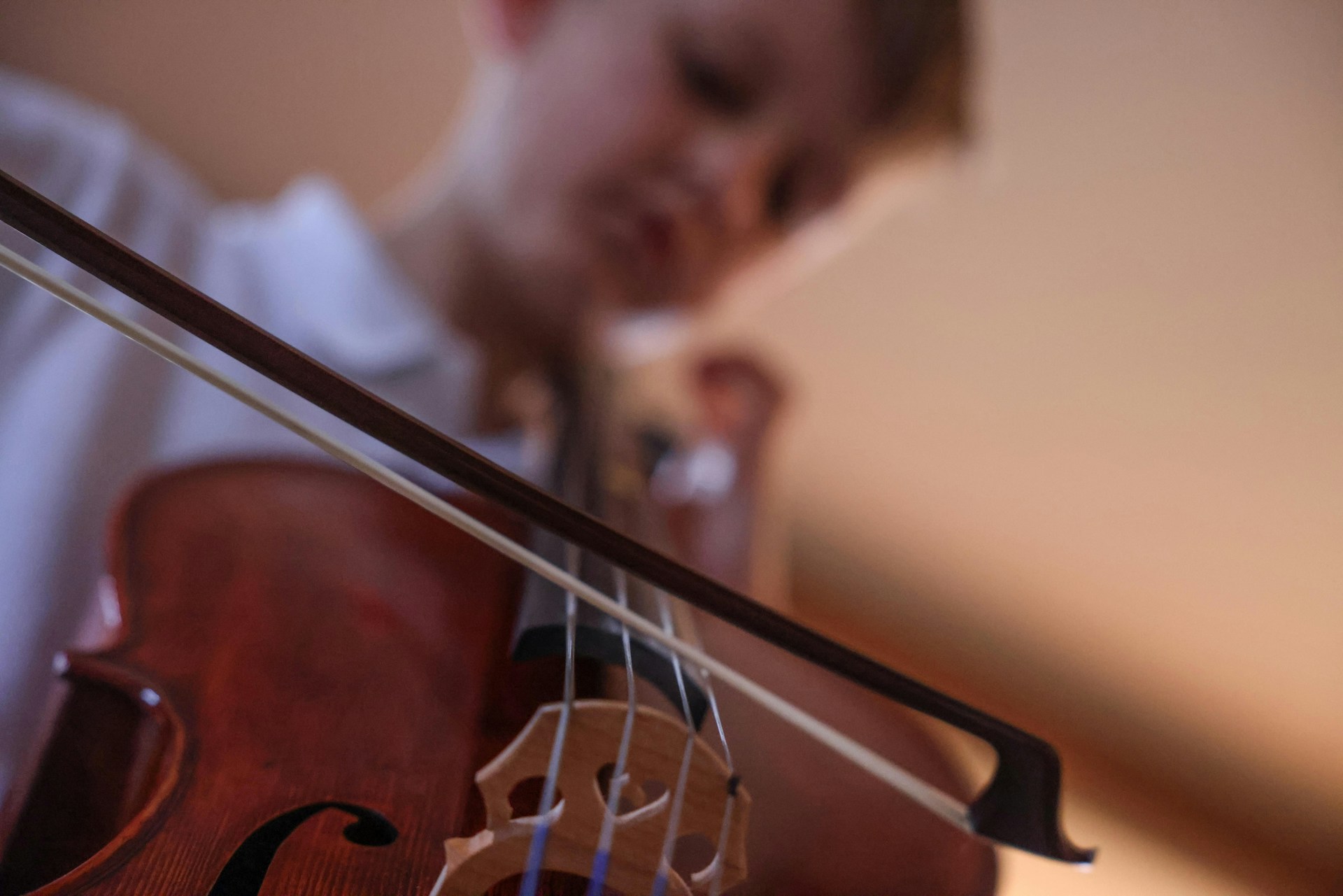 a young boy playing a violin in a room