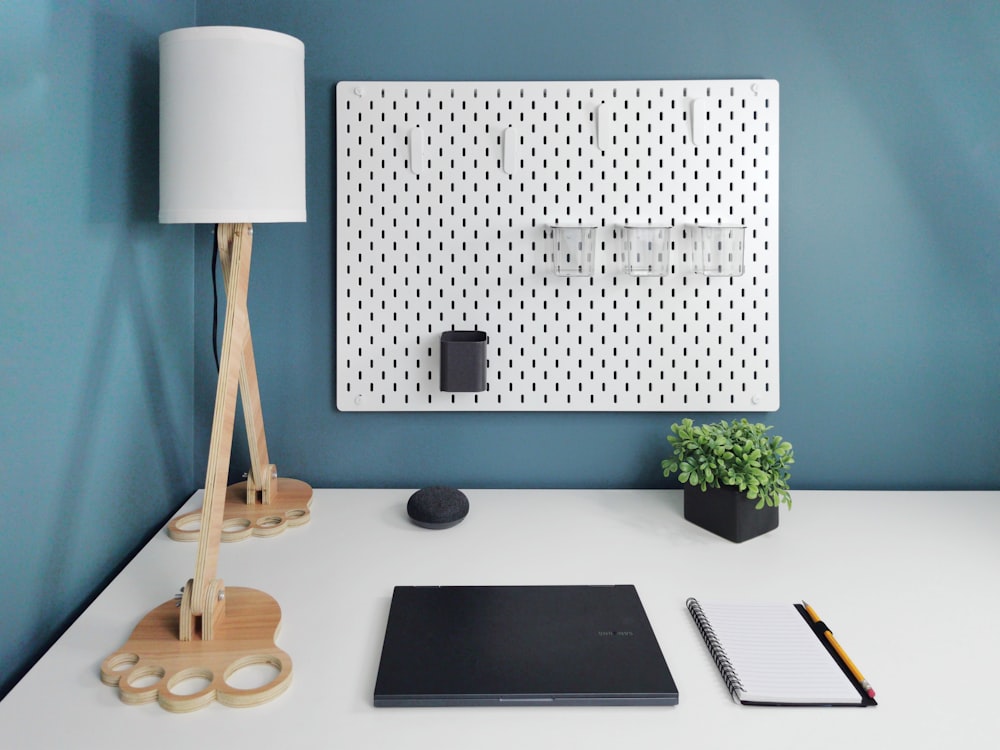 a white desk with a laptop and a lamp