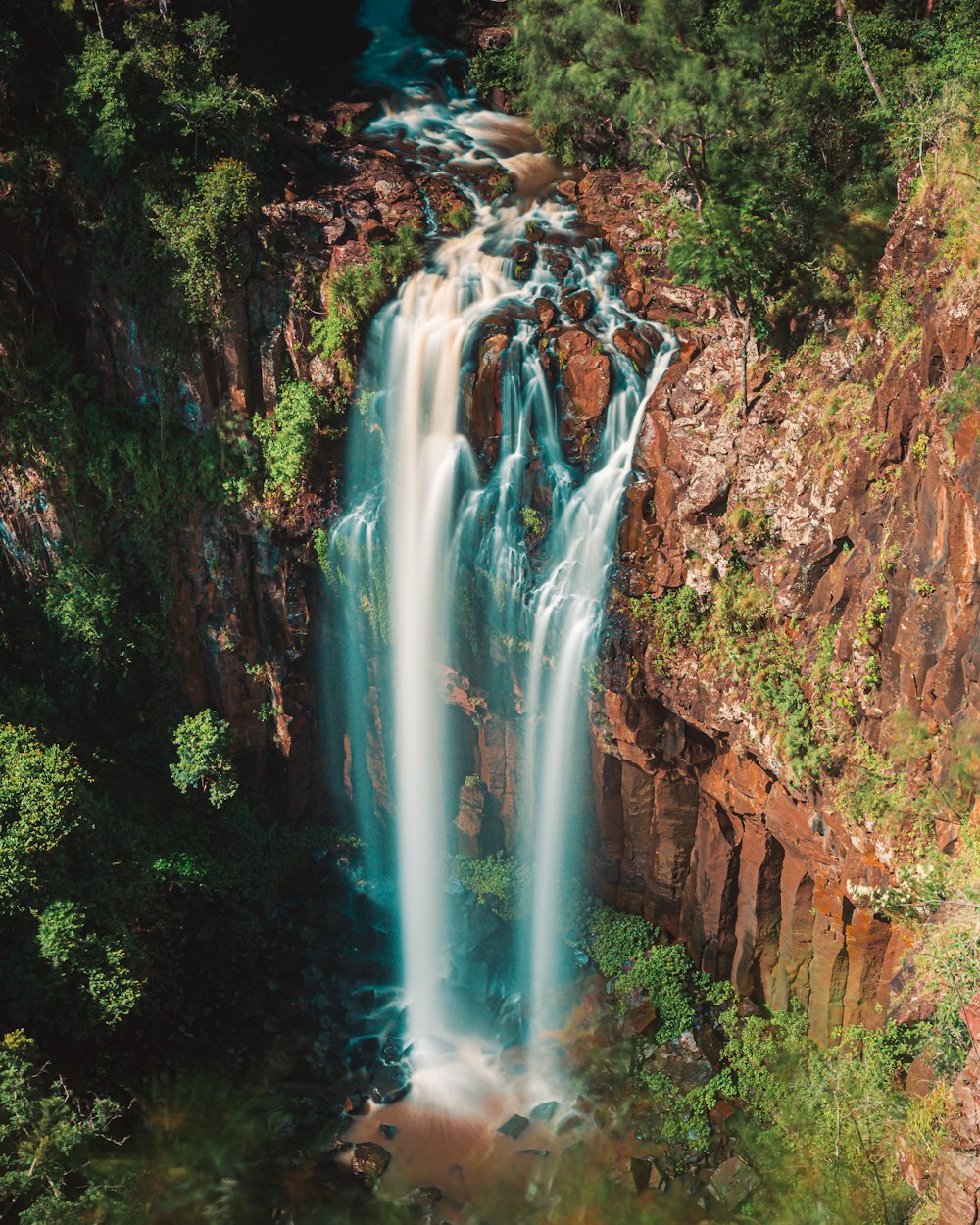 a large waterfall in the middle of a forest