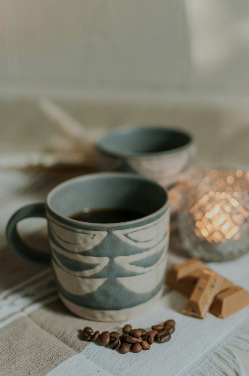 a cup of coffee and some chocolate on a table