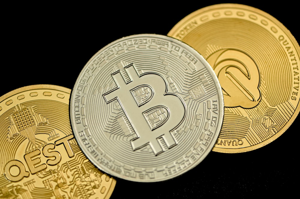 três bitcoins de ouro sentados um em cima do outro
