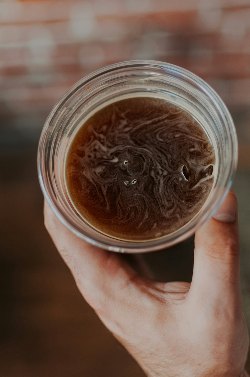 a person holding a cup of liquid in their hand