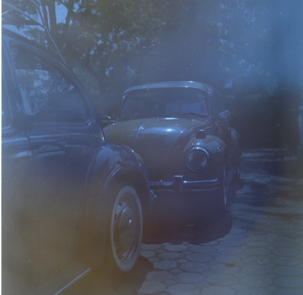 an old car is parked on the side of the road