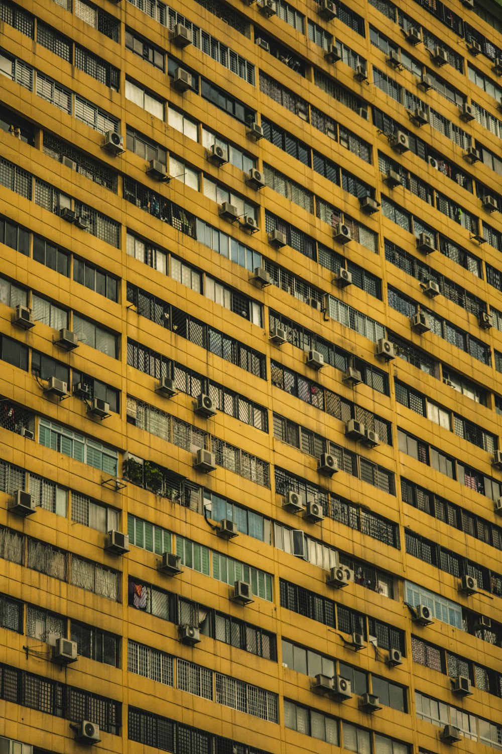 a very tall yellow building with lots of windows