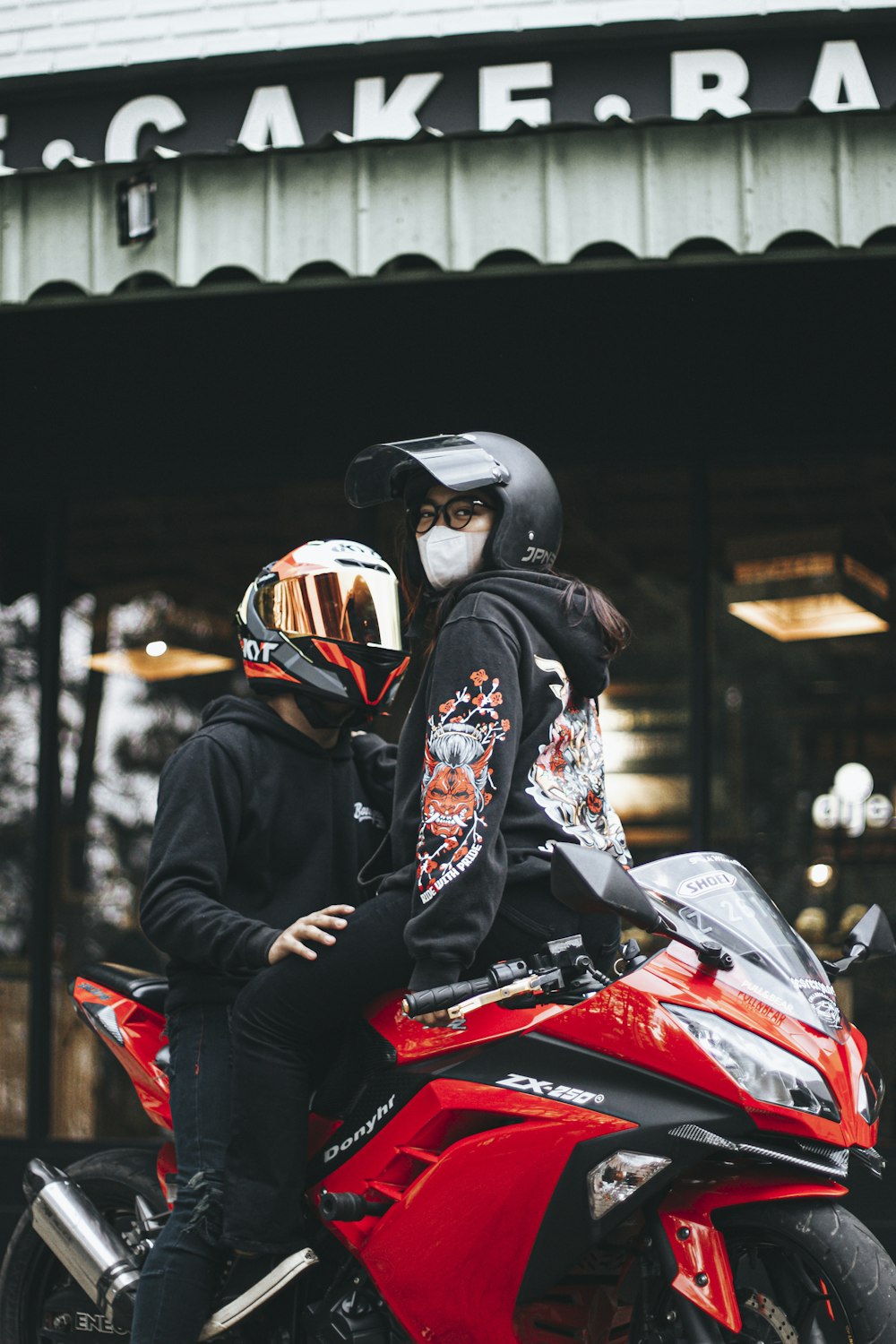 a man and a woman sitting on a red motorcycle
